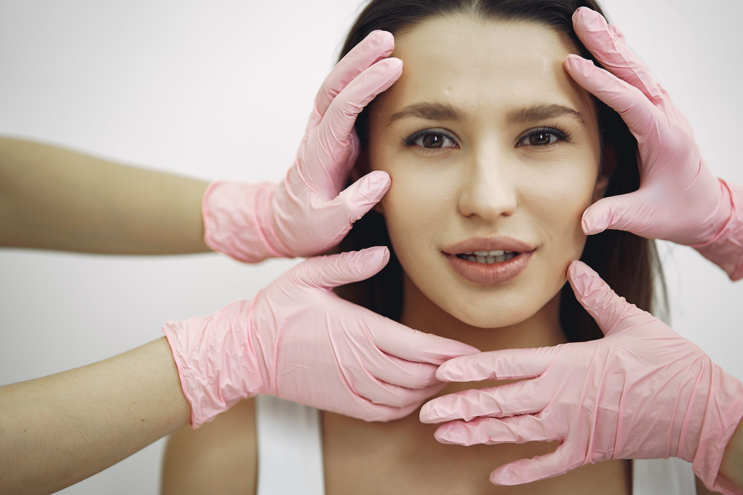 Woman looking forward and 4 pink gloves near her face