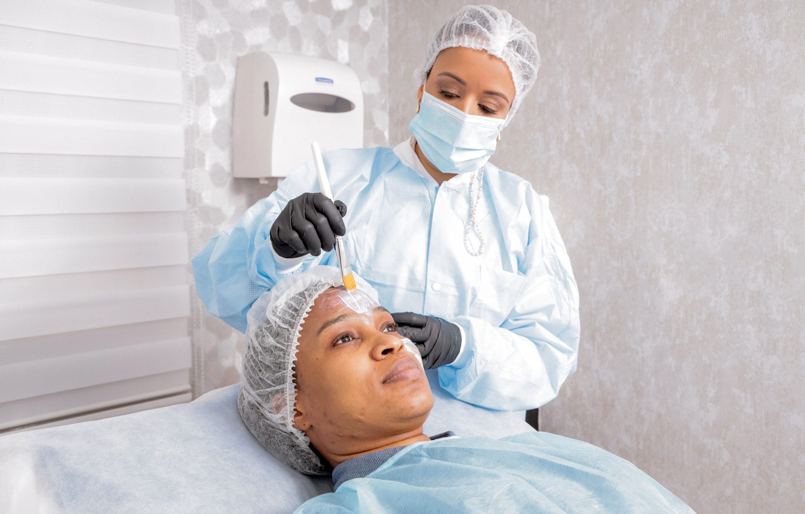 Esthetician giving a facial treatment to a patient